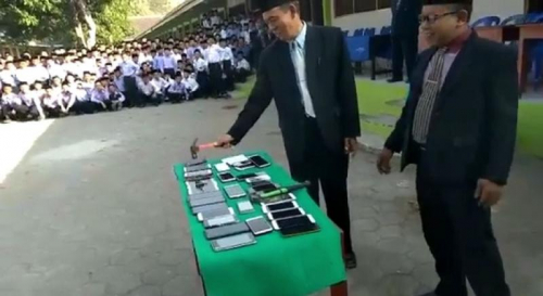 مقطع فيديو يوثق فيه مسؤول بإحدى المدارس الإندونيسية عقوبة إحضار الهاتف المحمول إلى المدرسة