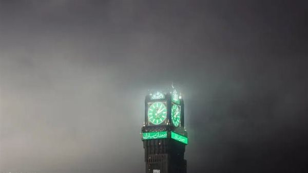 لوحة فنية مذهلة برج الساعة يظهر ويختفي وسط الغيوم في مكة المكرمة